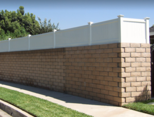 Vinyl wall topper installed on a stone wall, enhancing outdoor privacy and aesthetics, showcasing GNG Vinyl's durable fencing solutions.
