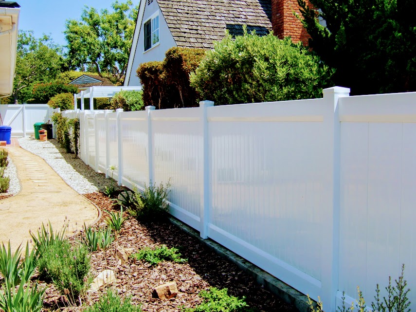 Vinyl fence near young landscaping
