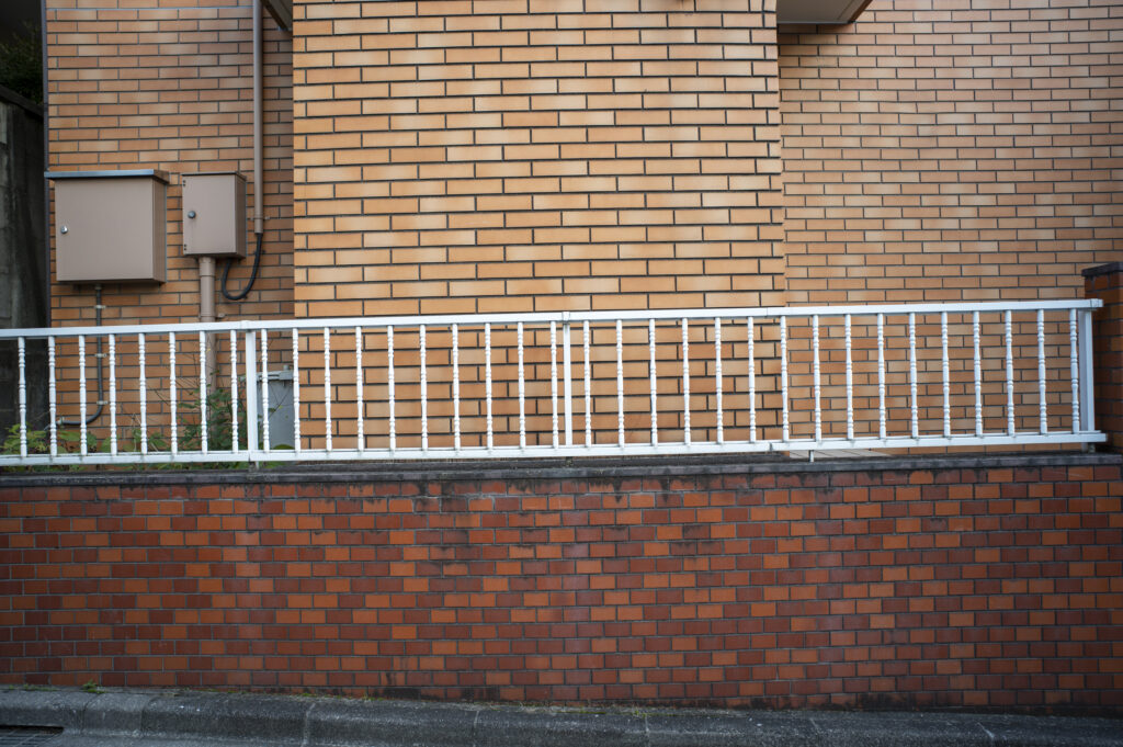 Vinyl railing installed on a brick wall, enhancing outdoor space aesthetics and durability, relevant to GNG Vinyl's fencing solutions.
